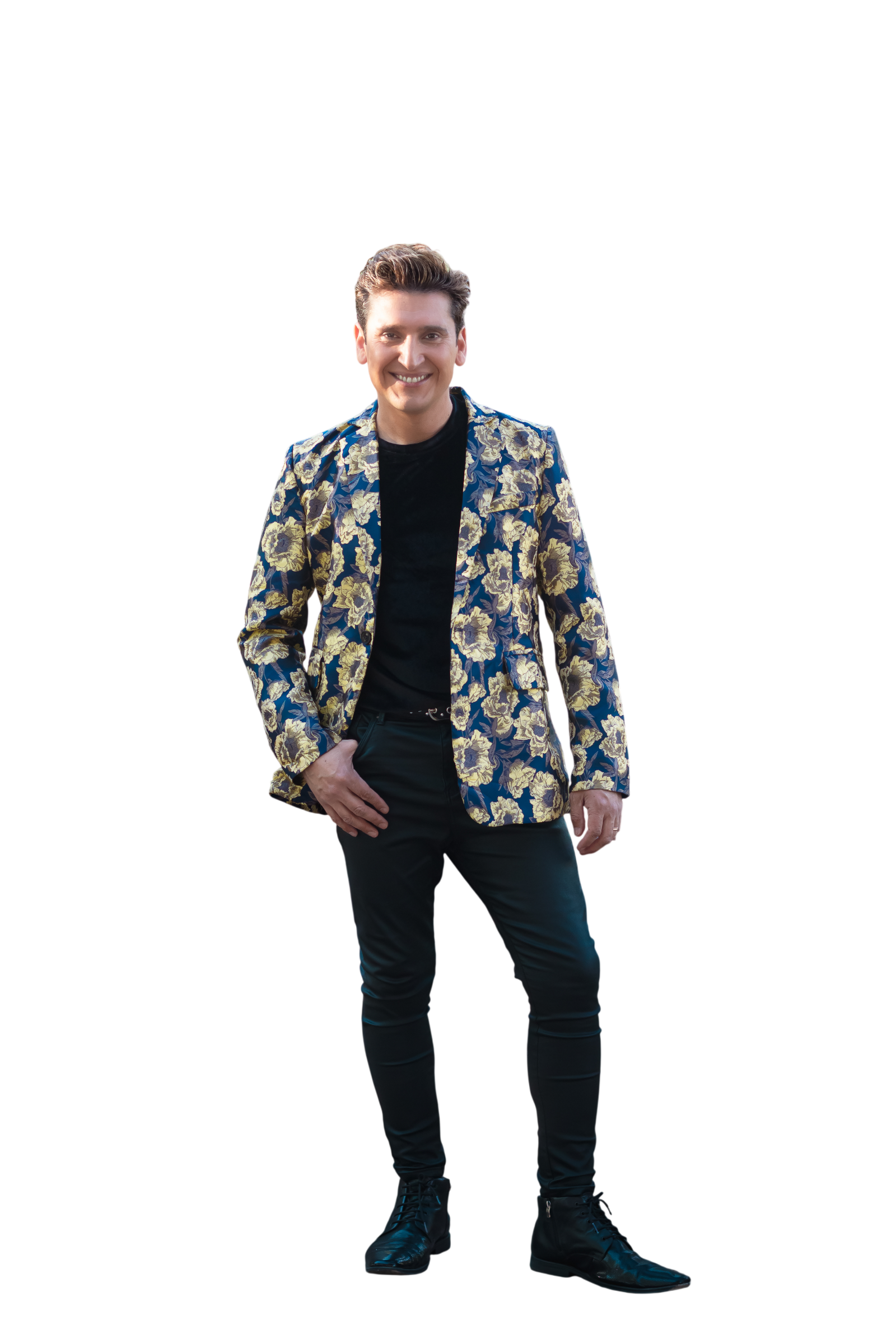 Jairo Quezada de pie, sonriendo, con blazer floral azul y dorado